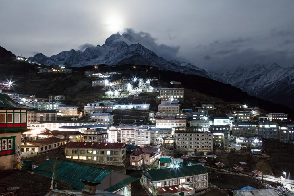 Namche Bazaar at night, lit by moonlight and scattered village lights, nestled in the Himalayan mountains