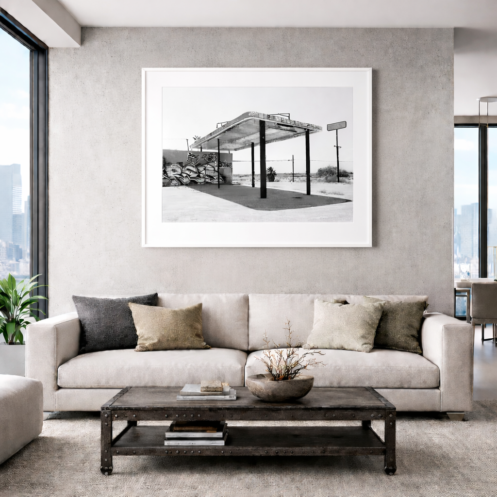 Deserted Refuel fine art photograph featuring an abandoned gas station structure in the desert landscape near the Salton Sea, California, shown here as a framed installation within a contemporary interior setting.